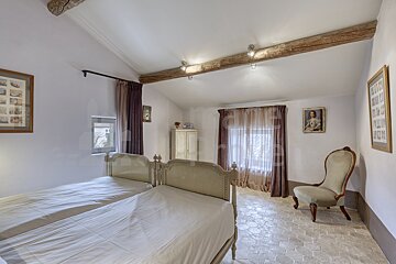 A bedroom with two beds and a chair with a picture of a woman on the wall