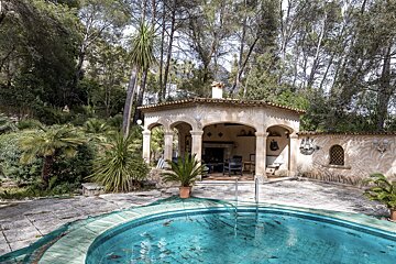 A swimming pool with a gazebo in the background