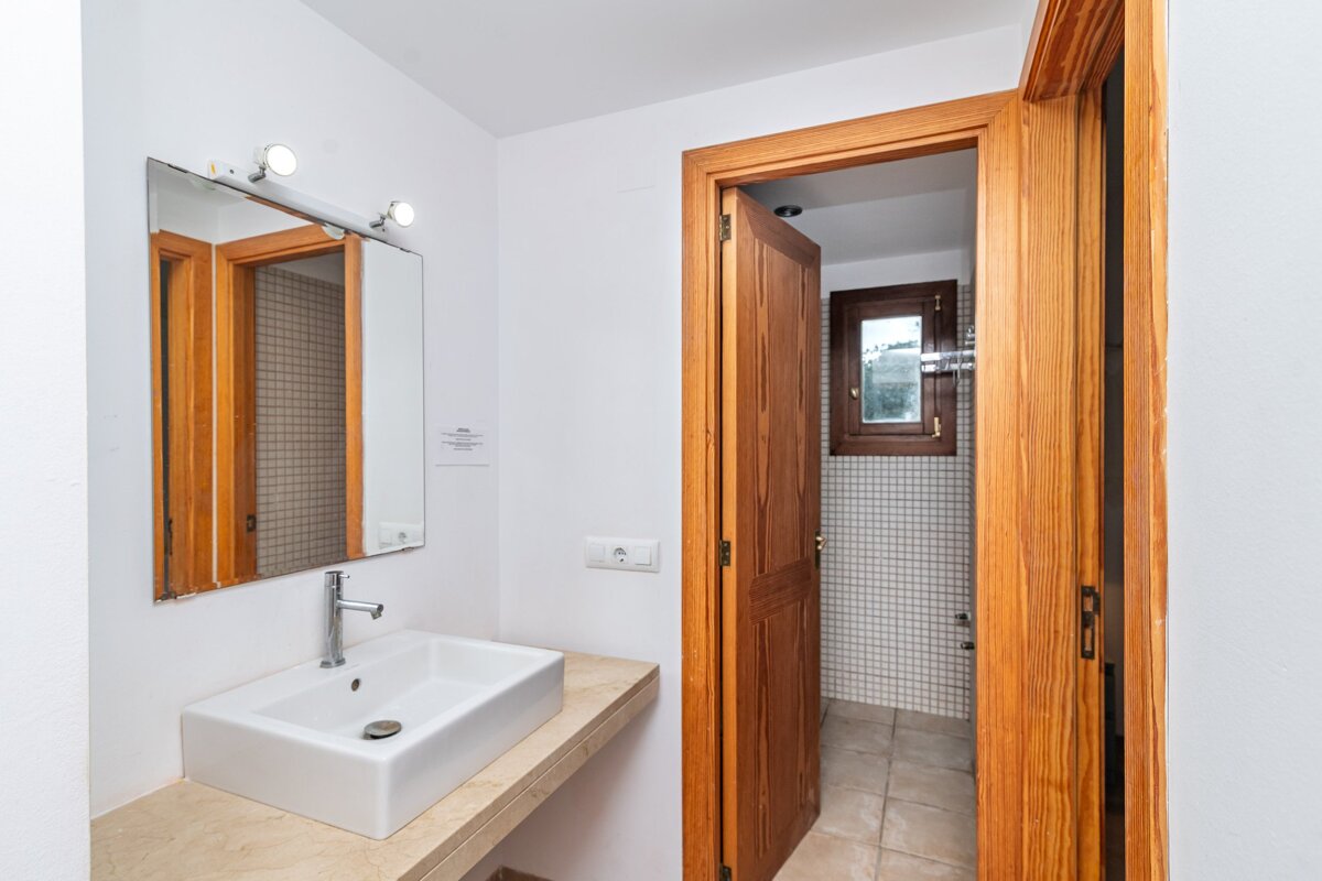 A bathroom with a sink a mirror and a door