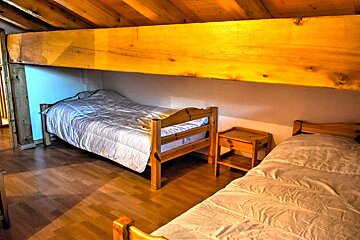 A bedroom with two beds and a bunk bed