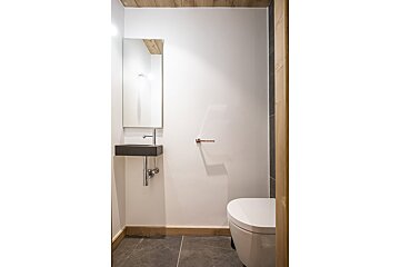 A bathroom with a toilet a sink and a mirror