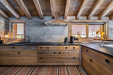 A kitchen with wooden cabinets and black counter tops
