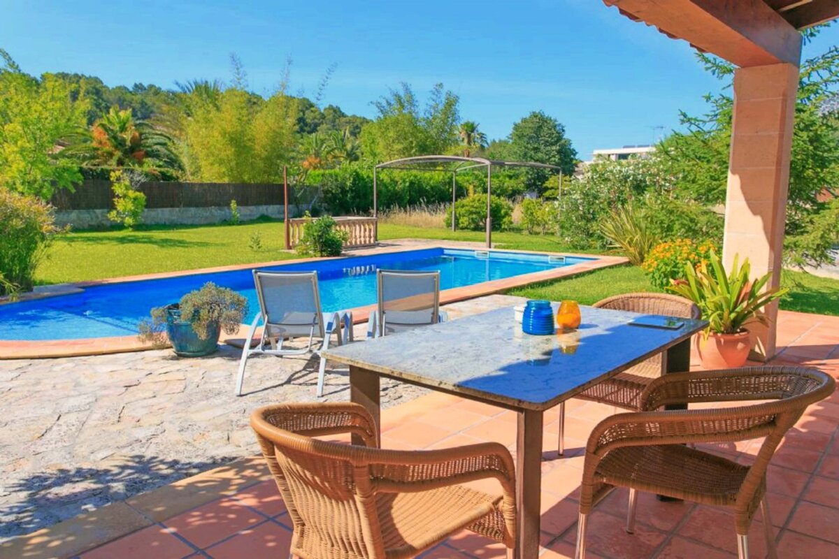 A table and chairs in front of a swimming pool