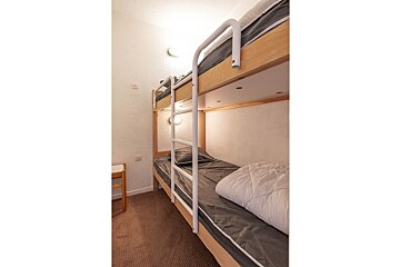 A bunk bed with a white comforter on it