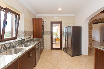 A kitchen with granite counter tops and a fridge