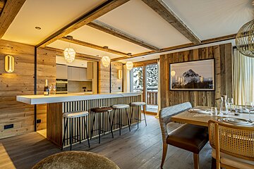 A dining room with a picture of a mountain on the wall