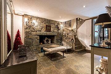 A stone fireplace with a picture on the wall above it