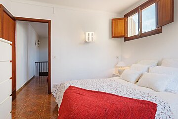 A bedroom with a red blanket on the bed
