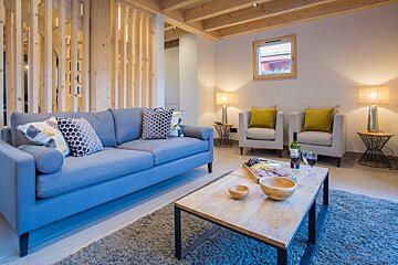 A living room with a couch and two chairs