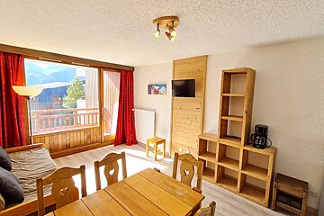 A living room with a table and chairs and a flat screen tv