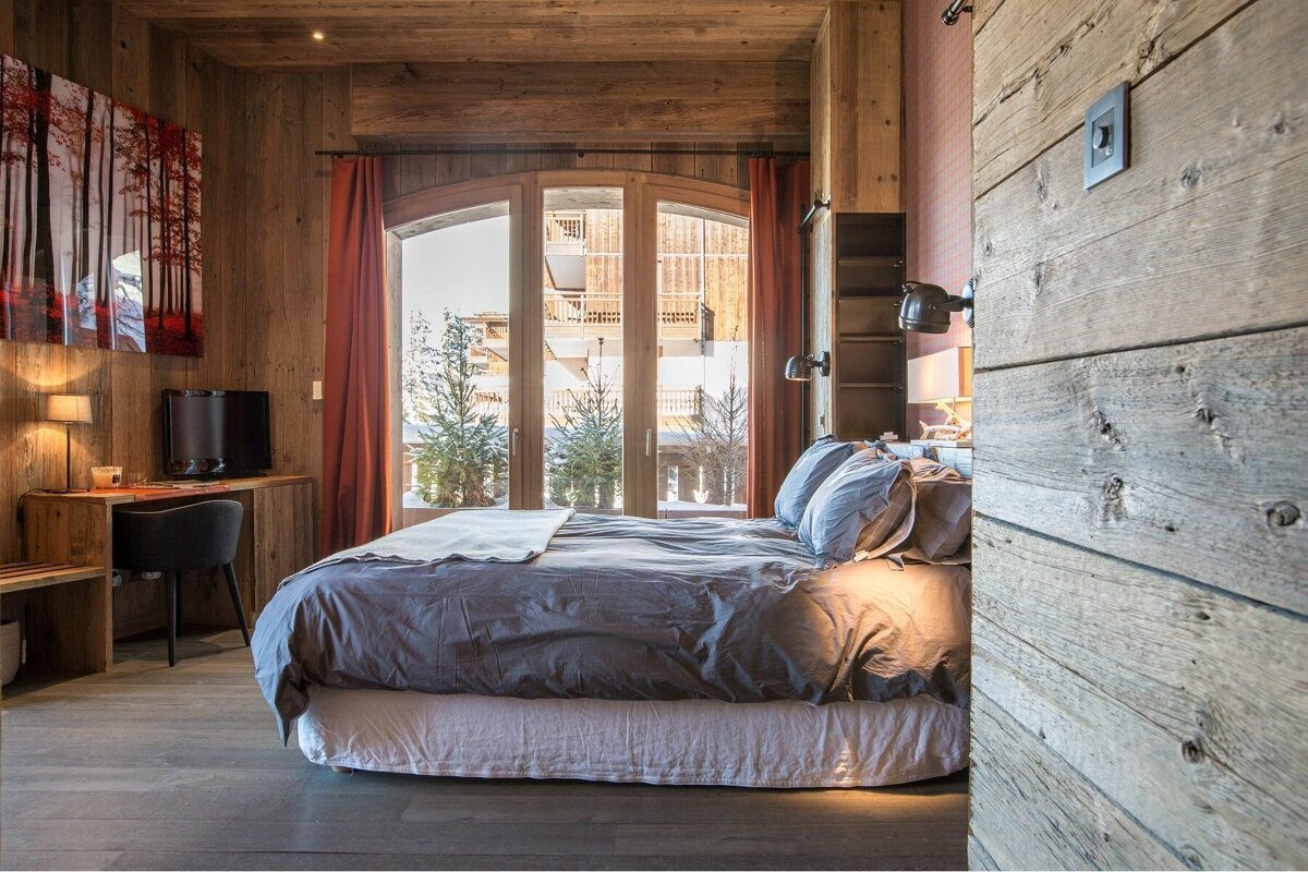 A bedroom with a large bed and a large window