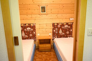 A bedroom with two beds and a nightstand