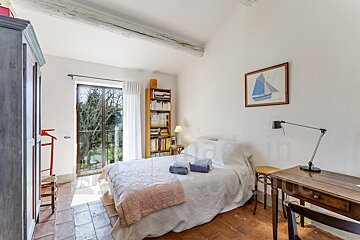 A bedroom with a picture of a sailboat on the wall