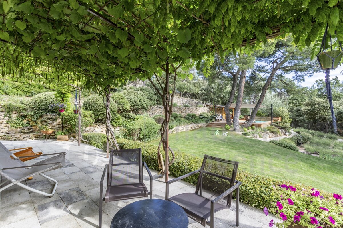 A patio with chairs and a table under a pergola