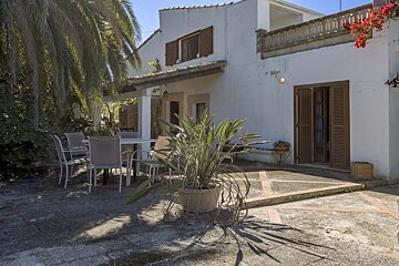 A white house with a patio area with a table and chairs