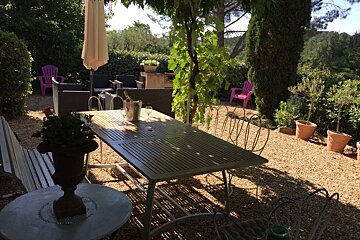 A patio with a table and chairs and an umbrella