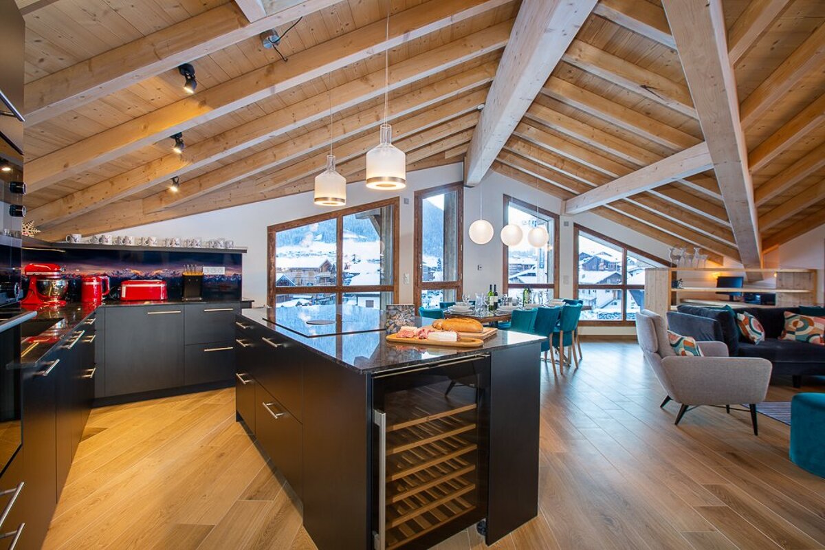 A kitchen with a large island and a wine cooler