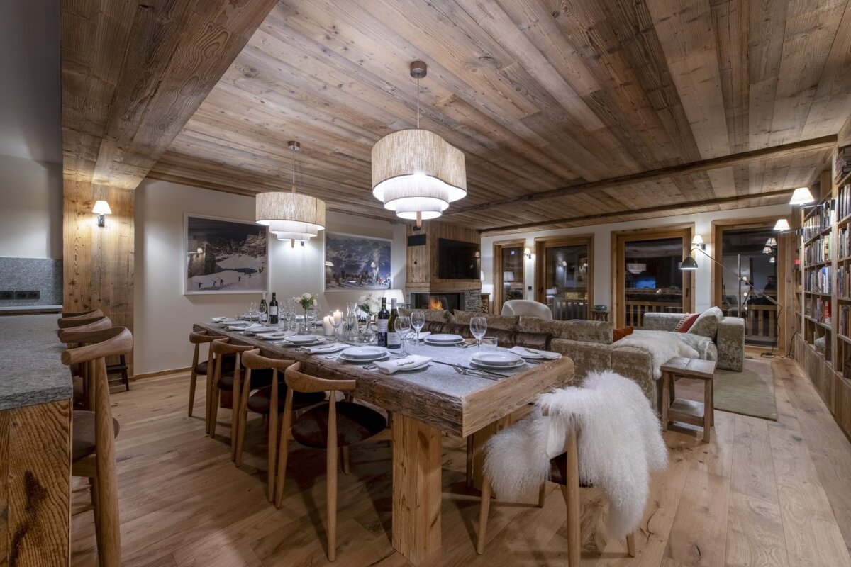 A dining room with a long wooden table and chairs