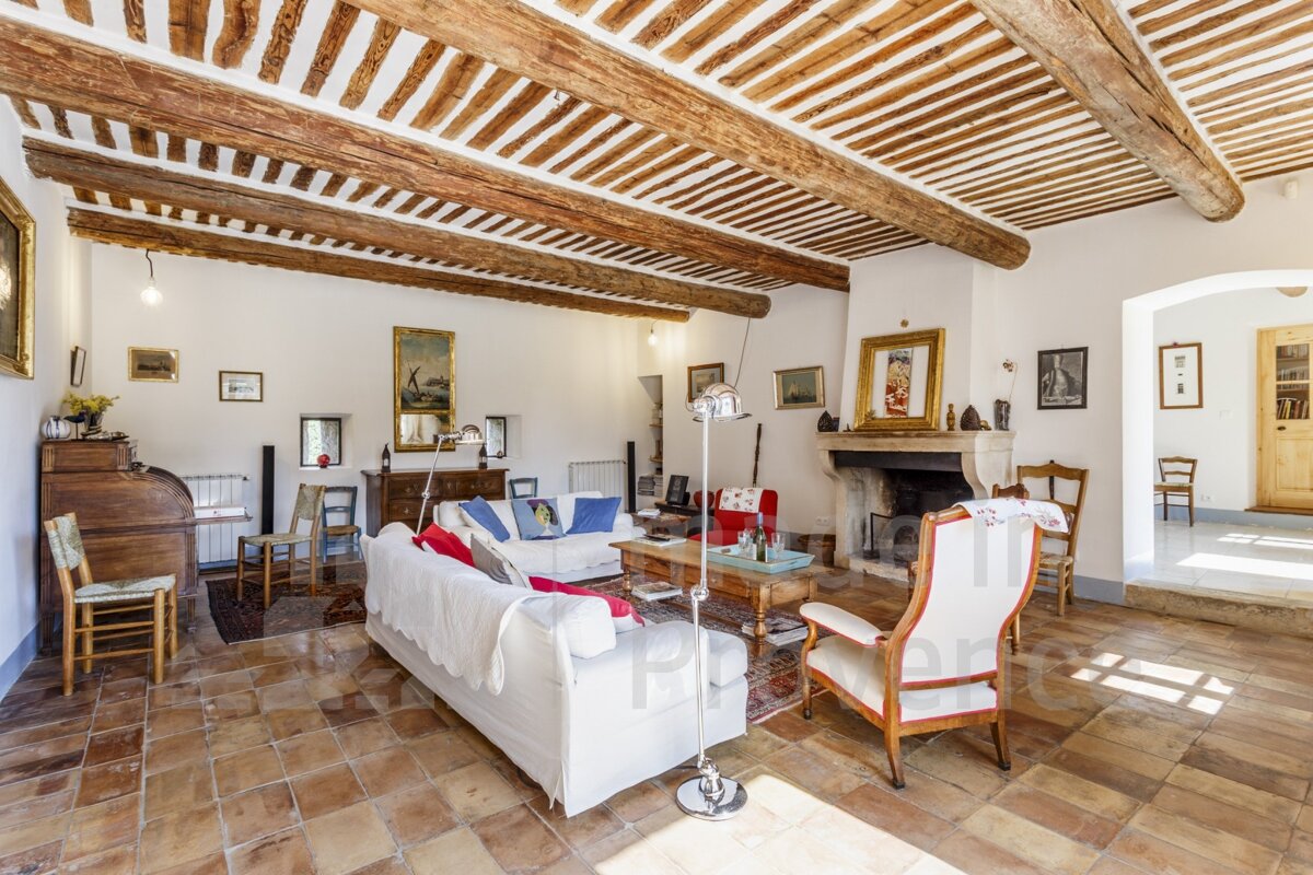 A living room with a couch and chairs and a fireplace with the word property on the bottom
