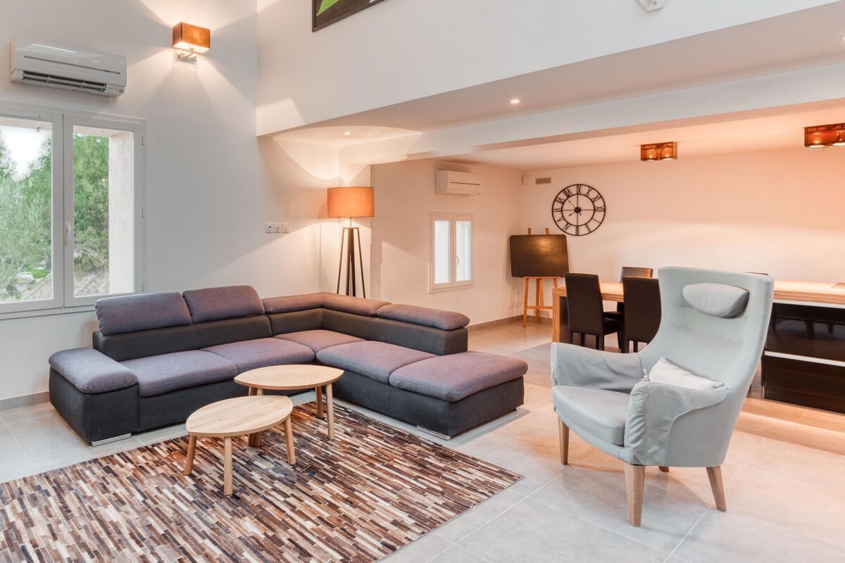 A living room with a clock on the wall above the couch