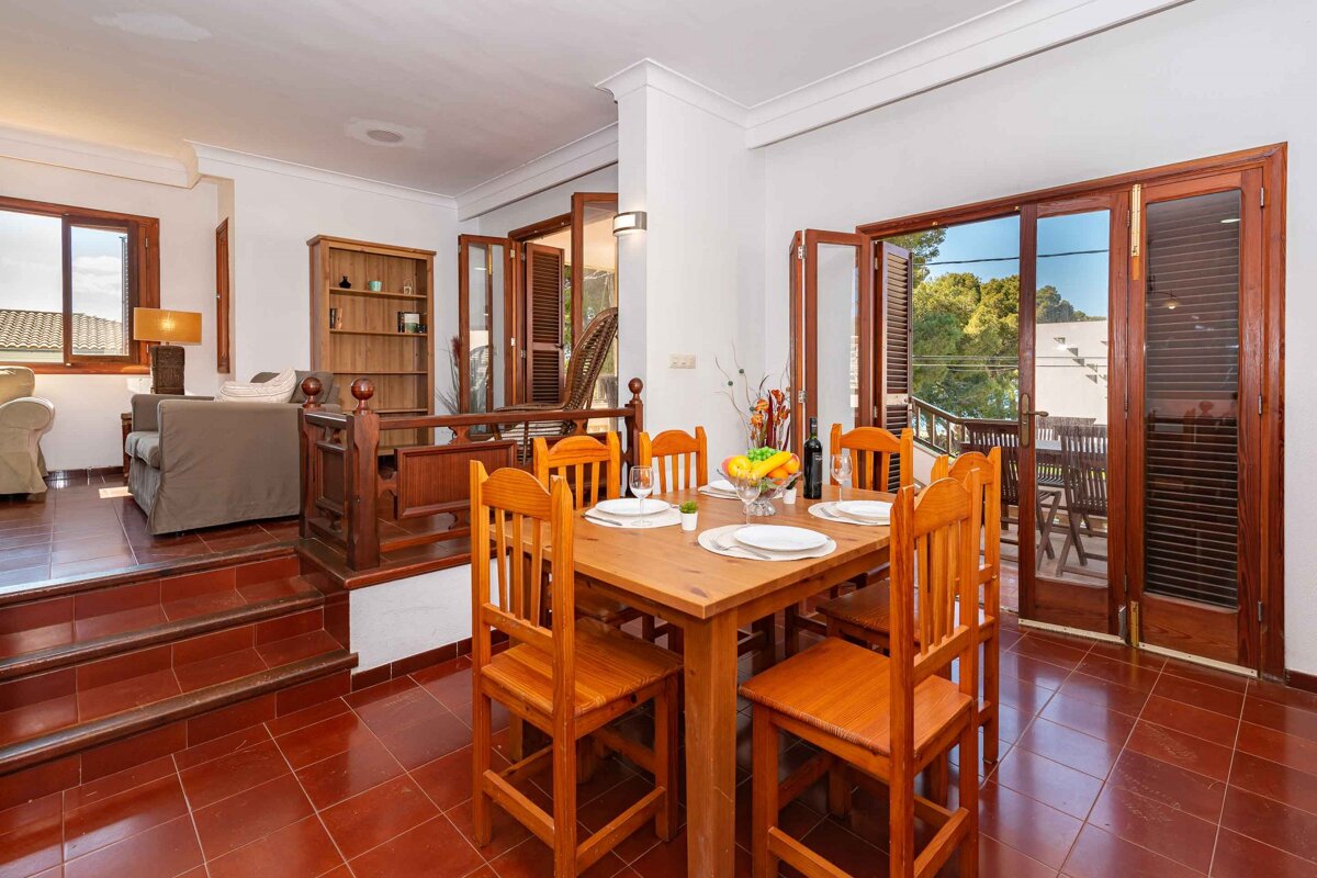A dining room with a wooden table and chairs