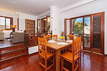 A dining room with a wooden table and chairs