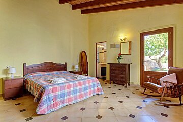 A bedroom with a large bed and a rocking chair
