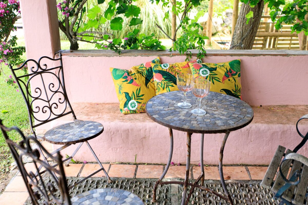 A table with two wine glasses and a yellow pillow with flamingos on it