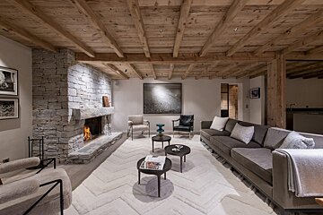 A living room with a stone fireplace and a couch