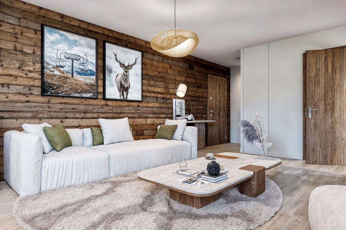 A cozy modern-rustic living room with a wood-paneled wall, white sectional, shaggy rug, unique coffee table, and ski lift/deer artwork.