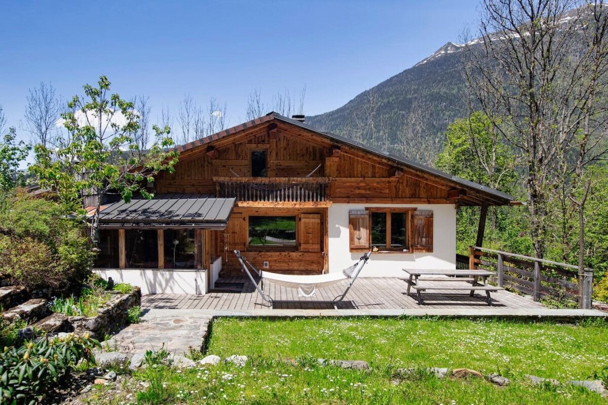 A wooden house with a hammock in front of it