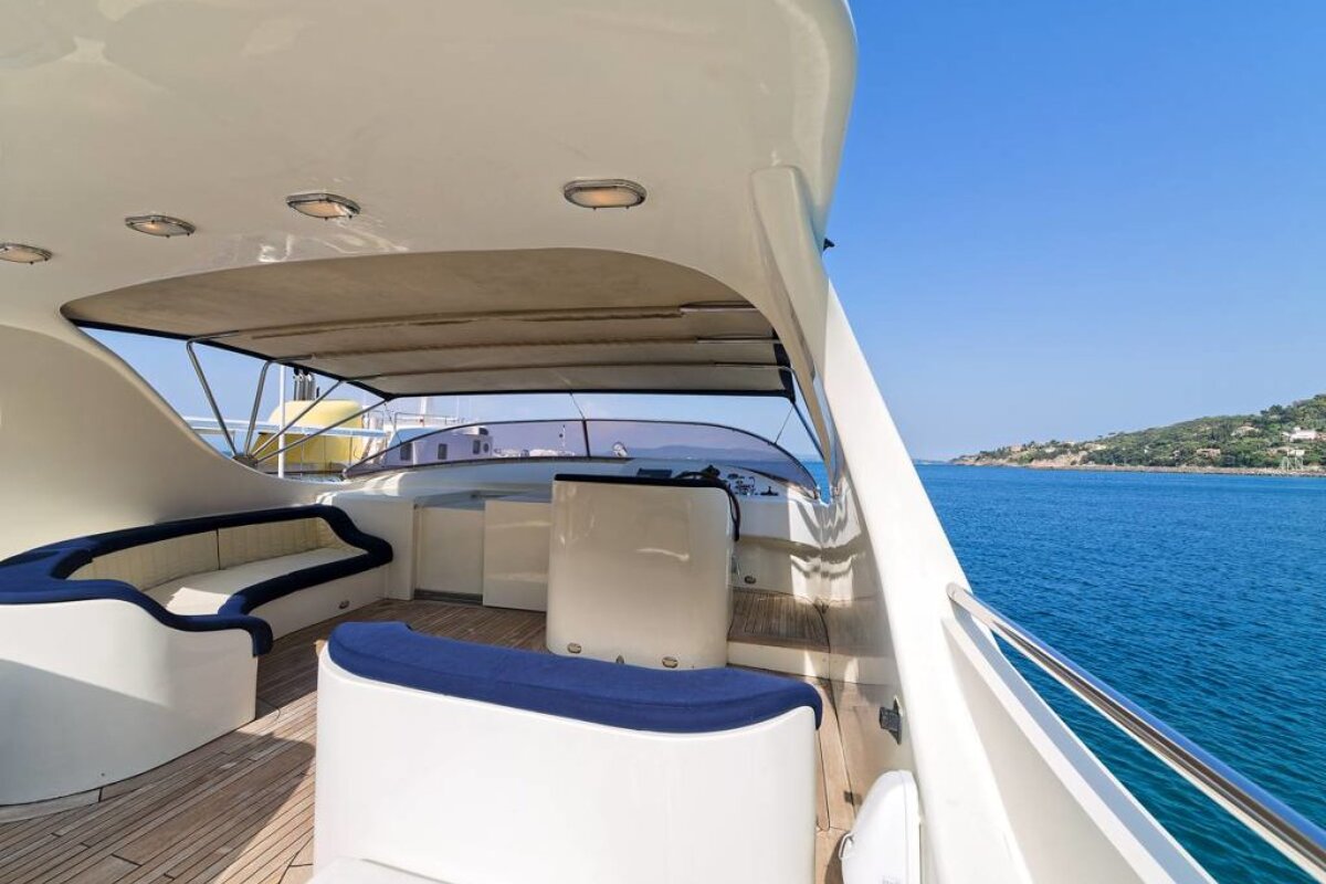 A boat with a couch and a steering wheel in the water
