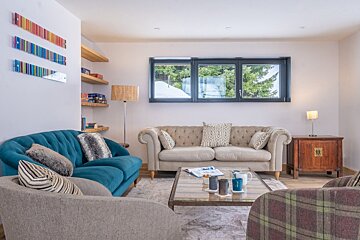 A living room with a blue couch and a white couch