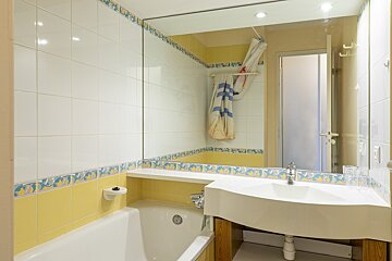 A bathroom with yellow and white tiles and a sink