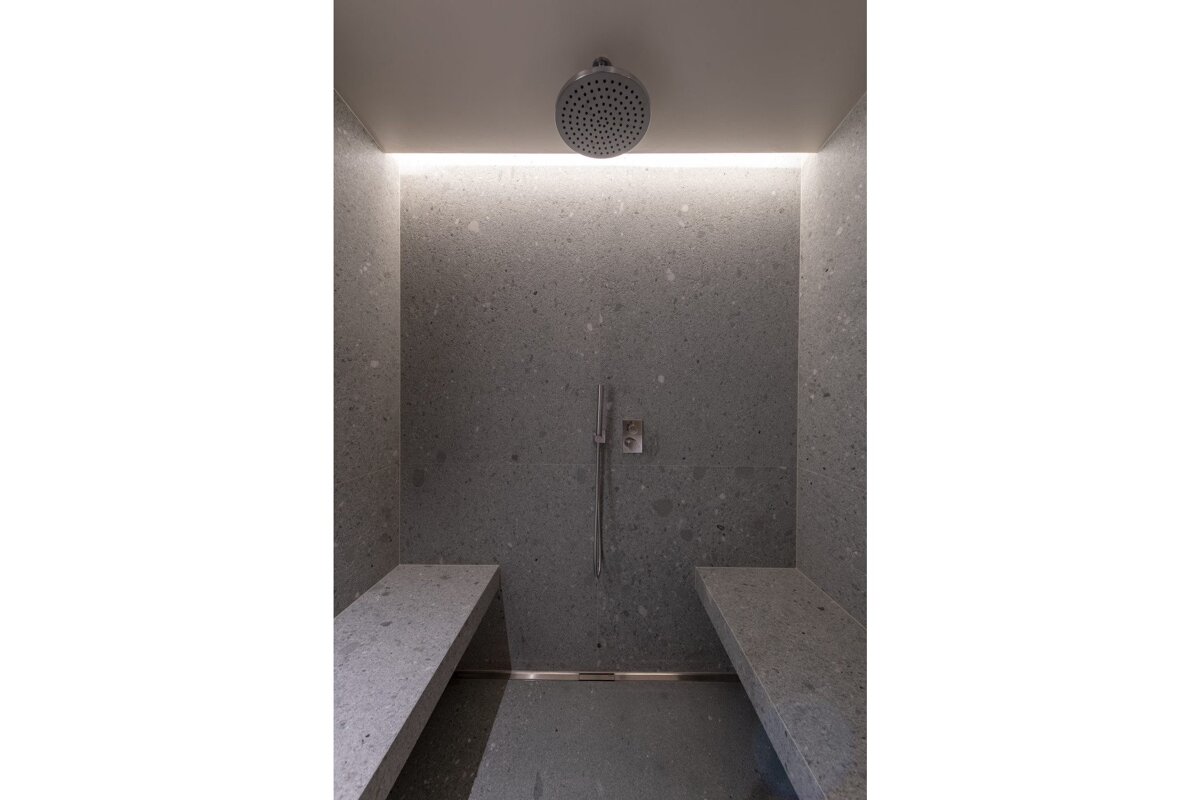 A bathroom with two benches and a shower head