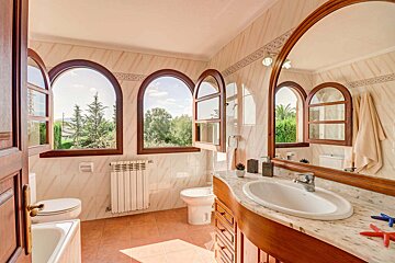 A bathroom with arched windows and a sink