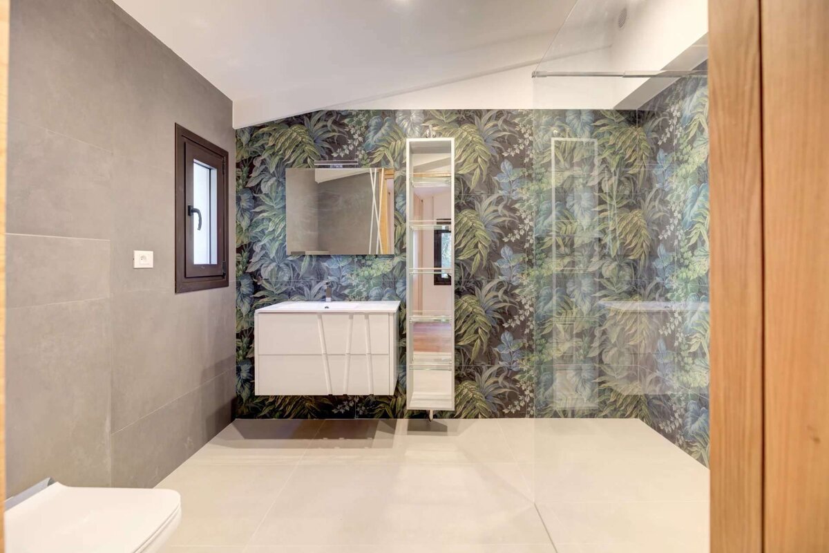 A bathroom with a floral wallpaper on the wall