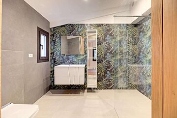 A bathroom with a floral wallpaper on the wall