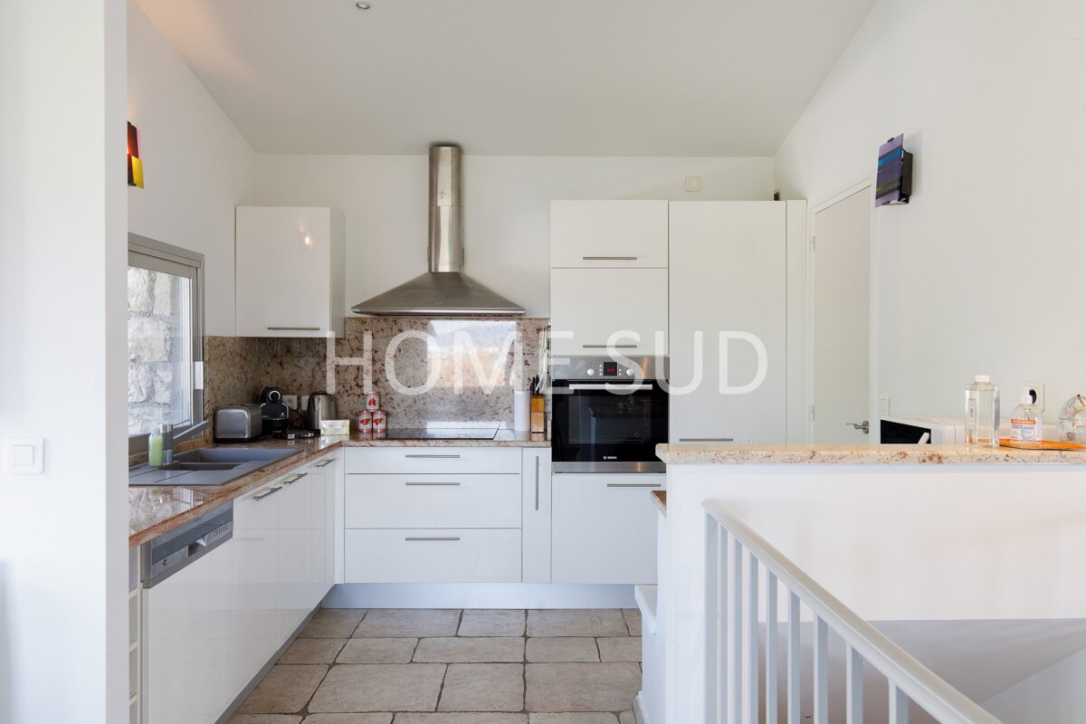 A kitchen with white cabinets and a sign that says homesud