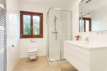 A bathroom with a toilet a sink and a shower