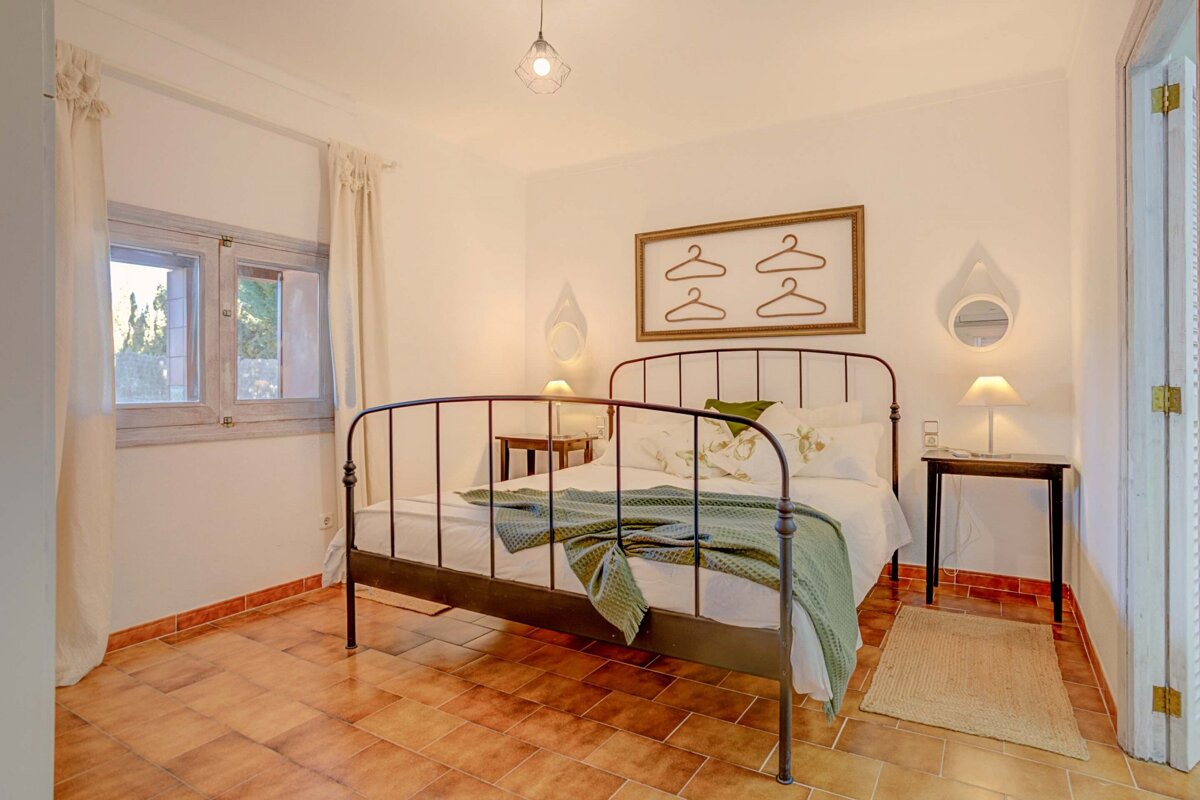 A bedroom with a bed and a picture on the wall