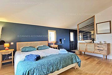 A bedroom with a king size bed and a bathroom by cannes accommodation