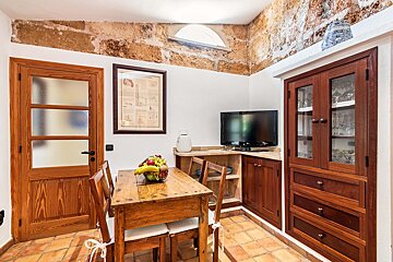A kitchen with a table and chairs and a television