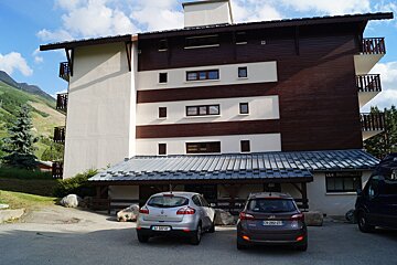 A silver renault car is parked in front of a building