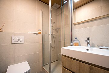 A bathroom with a toilet a sink and a shower