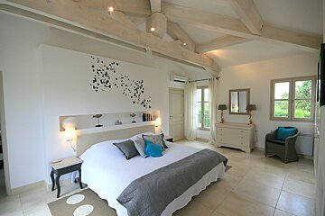 A bedroom with a large bed and a dresser