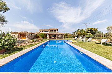A large swimming pool with a house in the background