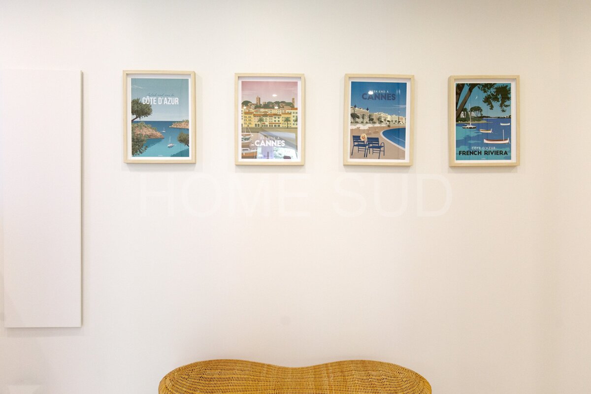 Four framed pictures on a wall one of which says cote d' azur