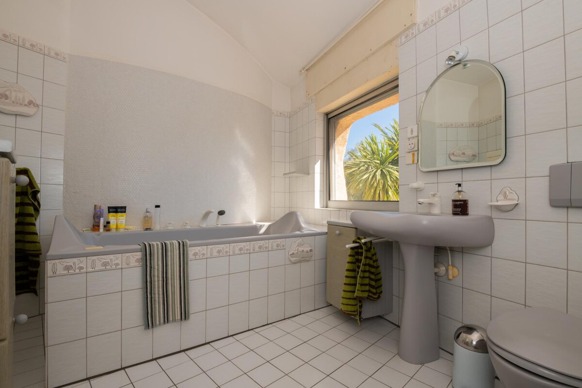 A bathroom with a tub and a sink and a mirror
