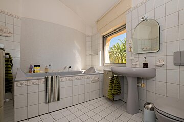A bathroom with a tub and a sink and a mirror